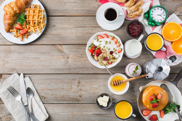 istock Breakfast table with waffles, granola, yogurt, pancakes, juice, coffee 960267618