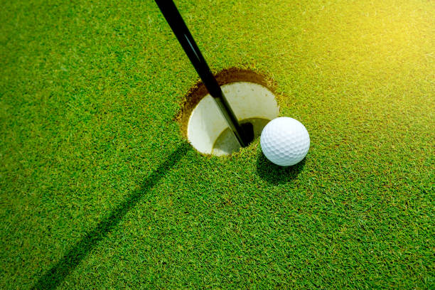 pelota de golf en el agujero en la hierba - golf flag fotografías e imágenes de stock