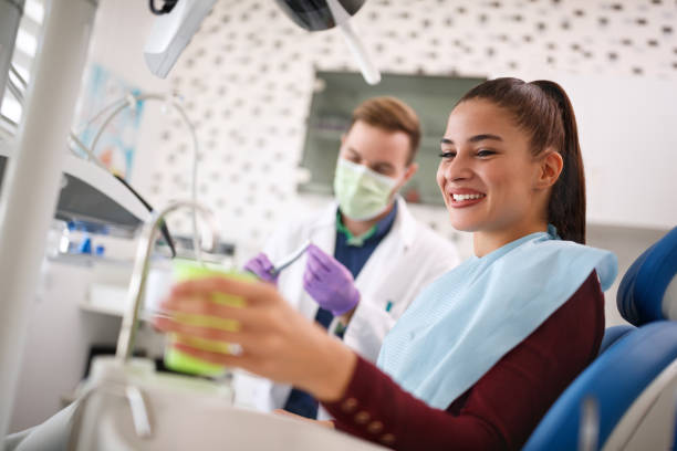 Female in dental ambulant taking cup of water Smiling female in dental ambulant taking cup of water ambulant patient stock pictures, royalty-free photos & images