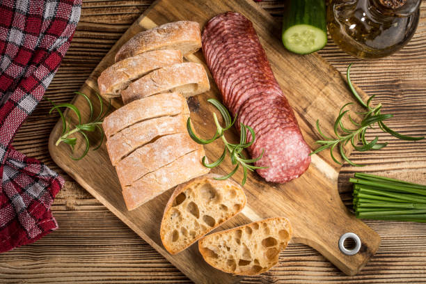 istock Italian ciabatta bread cut in slices with salami. 960274002