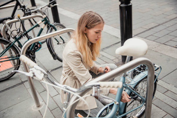 彼女は自転車をロック - fastening ストックフォトと画像