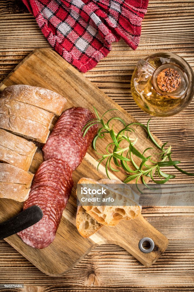 Italian ciabatta bread cut in slices with salami. Italian ciabatta bread cut in slices on wooden chopping board with salami. Bread Stock Photo