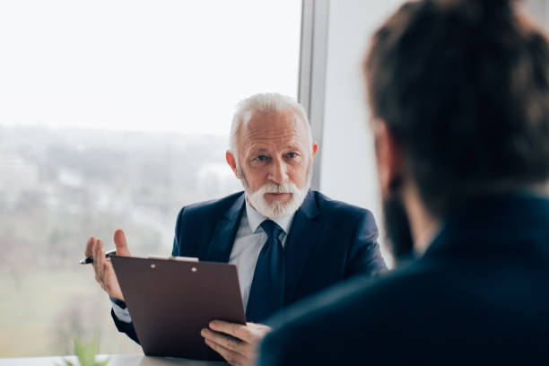 istock Senior businessman holding document talking with coworker 960277042