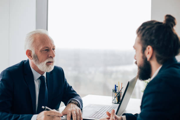 istock Elderly businessman having conversation with young coworker 960277960