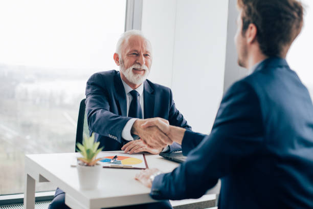 istock Coworkers shaking hands in office 960278112