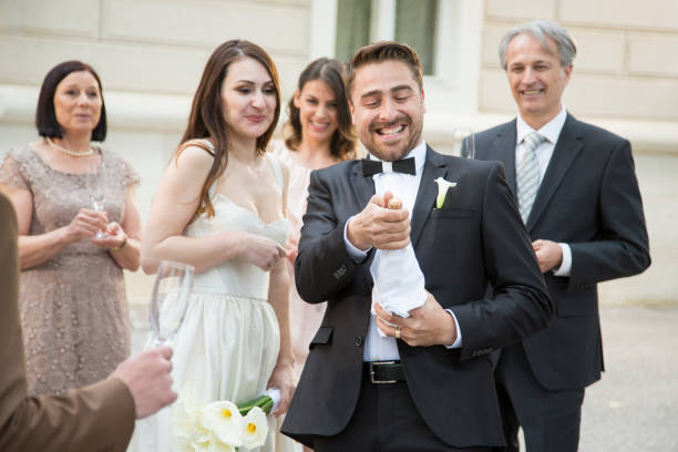 istock Groom opening champagne on his wedding 960278146
