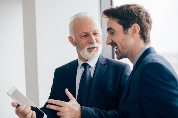 istock Business people holding tablet and talking 960280444