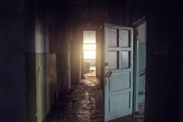 Dirty empty dark corridor in abandoned building, doors, light in the end, perspective, way to freedom