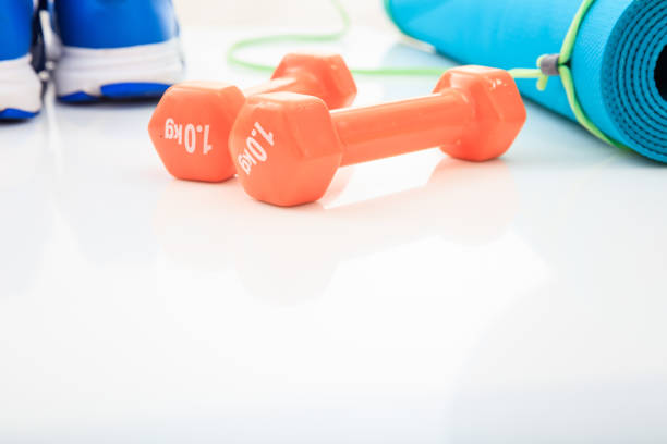 Unrecognizable fit woman lifting weight isolated on pink background