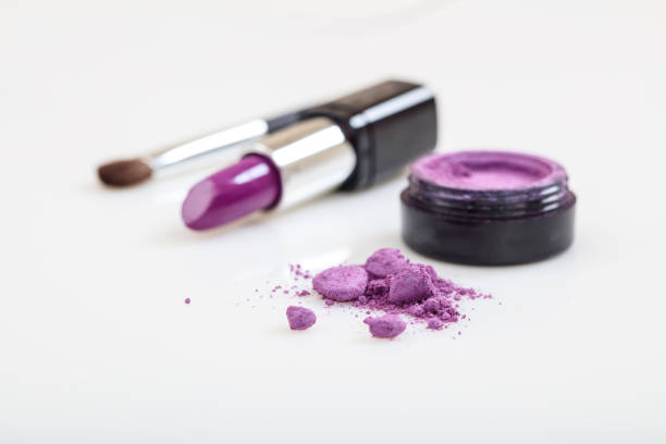 Lipstick and eye shadow close up on white background