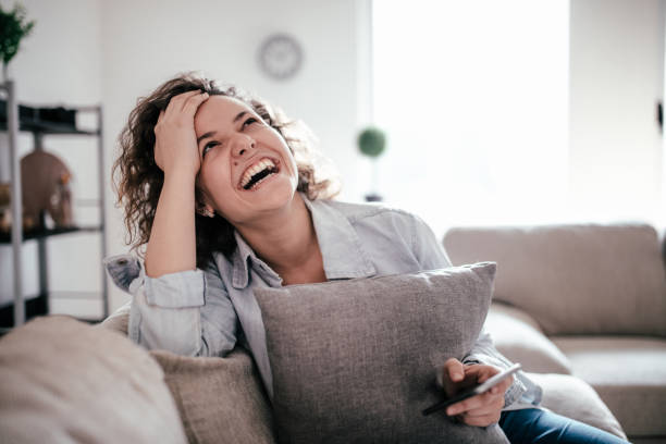 istock Woman uses cellphone on sofa at home 960299168