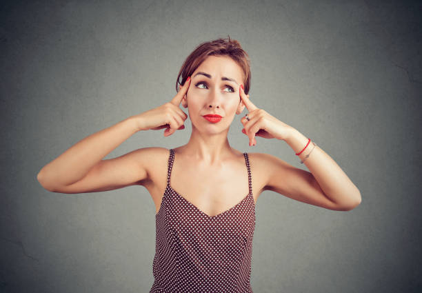 istock woman tries to gather with thoughts, thinking about something, looking with doubt up 960301776