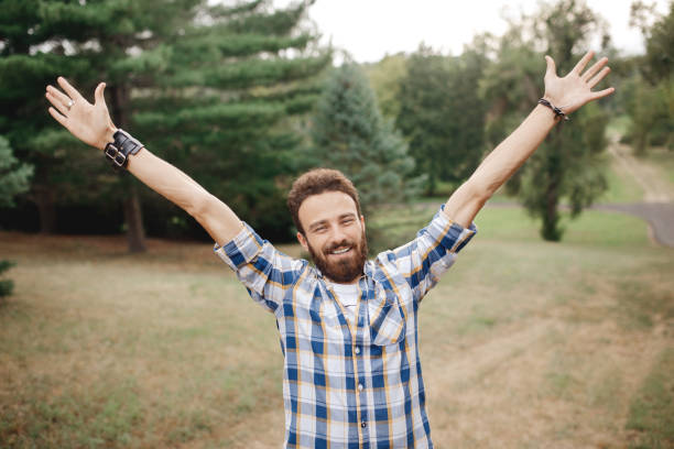 istock Happy excited celebrating bearded man posing with hands upin the park. 960305616