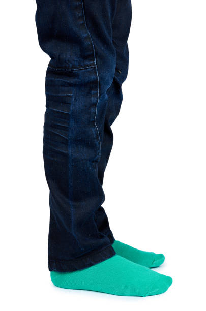 istock Kid legs in colored socks on leg isolated on white background 960307052