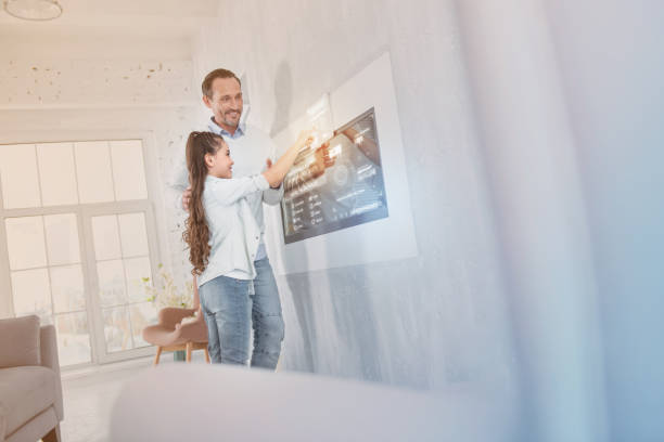 istock Emotional relatives smiling while standing near the wall and touching a gadget 960315256