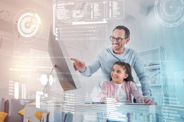 istock Smiling father pointing to the screen while doing homework with his daughter 960316774