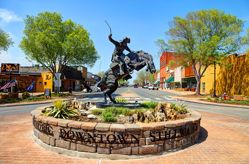 Stillwater, Oklahoma, USA - April 24, 2018: Daytime view of the enlarged bronze replica of 'The Bronco Buster' by famed sculptor Frederic Remington in a roundabout on Main Street in Stillwater Oklahoma