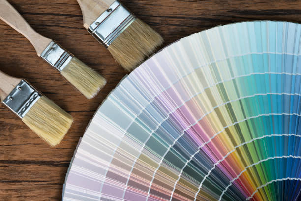 istock Painter and decorator work table with house project, color swatches, painting roller and paint brushes 960327190