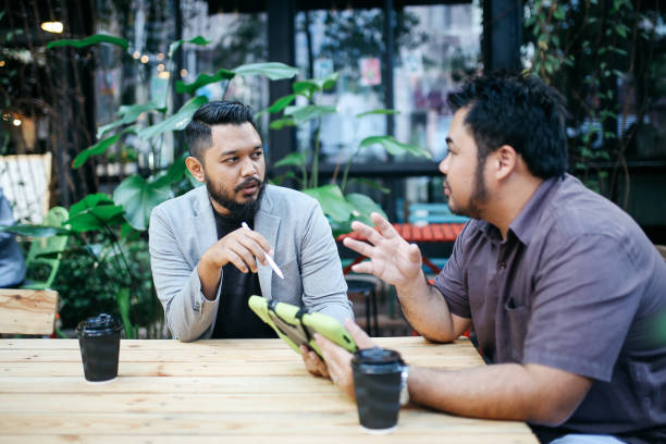 istock Two young men sitting and talking in Kuala Lumpur on a coffee break 960333508