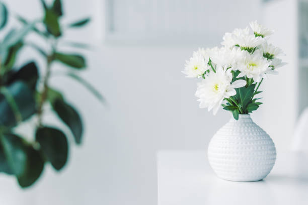 istock selective focus of white flowers in vase on table 960337282