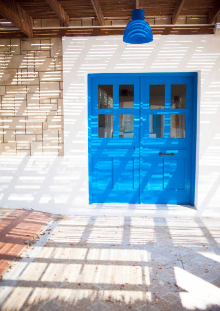 Traditional greek house with blue doors and white wall, travel stylish photo