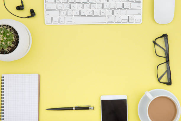 istock workspace with tablet, keyboard, coffee cup and eyeglasses copy space on yelow background. Top view. 960347968