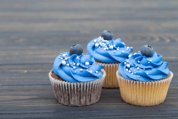 istock Tasty cupcakes on a white wooden table 960348020