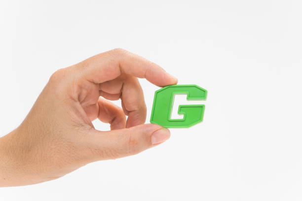 istock Female hand holding Plastic alphabet letter G 960348744