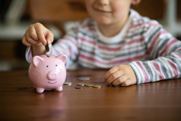 istock Kid put coin to piggy bank 960352376