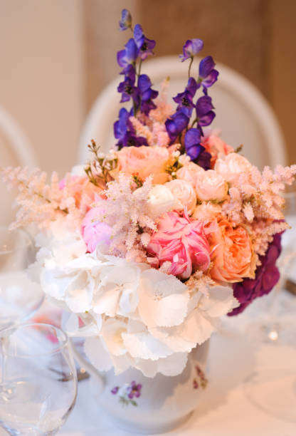 istock Dining table setting at Provence style, with candles, lavender, vintage crockery and cutlery, closeup. Beautiful wedding decoration with flowers pink violet purple white colors 960353676
