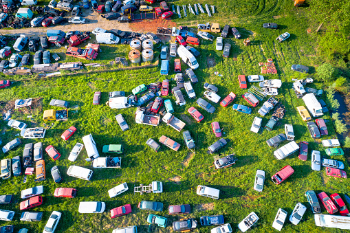 Car wrecks on meadow aerial view, ecological problem