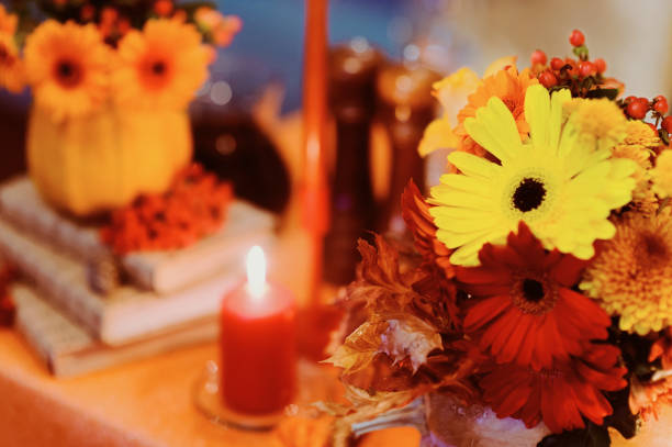 istock Autumn wedding decoration with flower composition with roses, chrysanthemum, maple leaves, pumpkin, books and candles. Haloween concept 960367454
