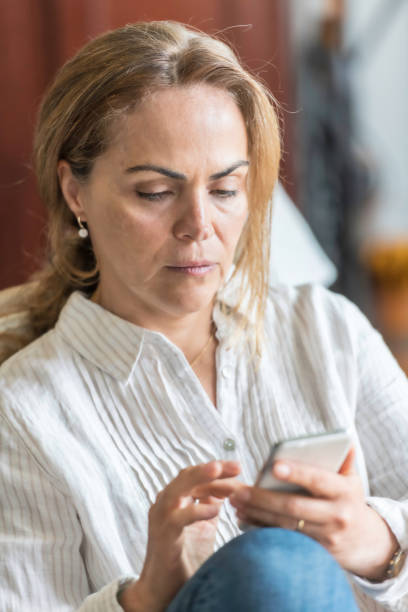 istock mature woman looking at her smart phone 960367842