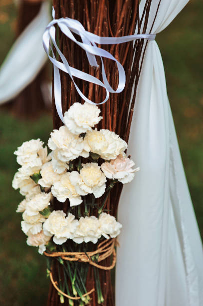 istock Rustic wedding decoration with flowers and branches. Flowers in a mason jar a wedding ceremony. Seating guests. Wedding ceremony details. Selective focus wedding celebration party reception catering 960371822