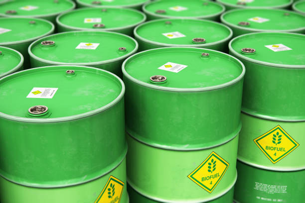 Group of rows of green stacked biofuel drums in storage warehouse stock photo