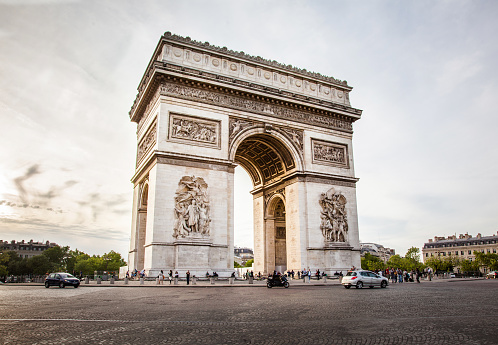 Paris, France - May 11, 2018: Triumphal Arch of the Star (Arc de Triomphe de l'Etoile) with traffic and few people nearby