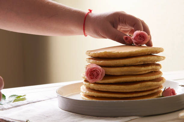 pancakes plate on the table decorated with rose flowers - baking margarine studio shot macro imagens e fotografias de stock