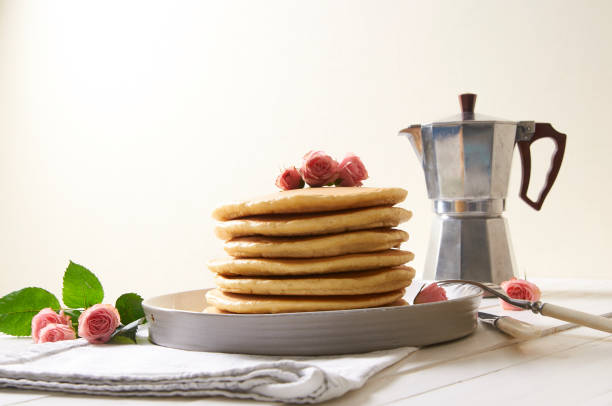 pancakes plate on the white table decorated with rose flowers - baking margarine studio shot macro imagens e fotografias de stock