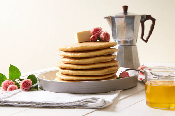 pancakes plate on the white table decorated with rose flowers - baking margarine studio shot macro imagens e fotografias de stock