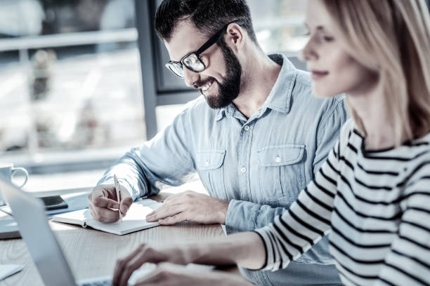 istock Satisfied unshaken man sitting and writing 960389022