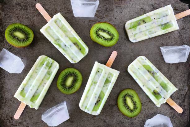 istock Healthy kiwi yogurt popsicles, top view on a dark background 960393842