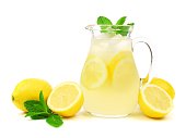 Jug of lemonade with lemons and mint isolated on white