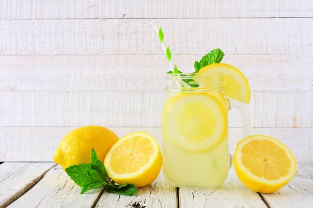 istock Lemonade in a mason jar glass with a white wood background 960394142