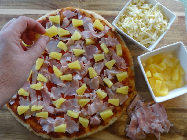 aggiunta di ananas alla pizza - human hand baked food pineapple foto e immagini stock