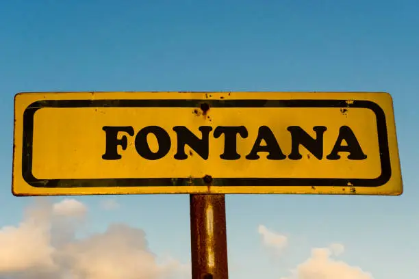 Fontana city street old antique yellow sign with blue sky at background, USA signal city series.