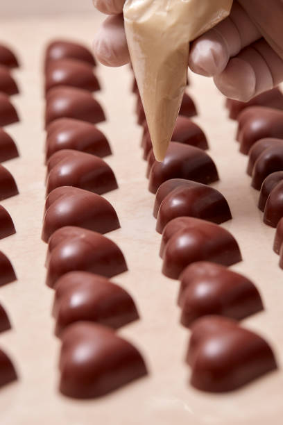 istock heart-shaped chocolates being decorated with a gloved hand 960428038