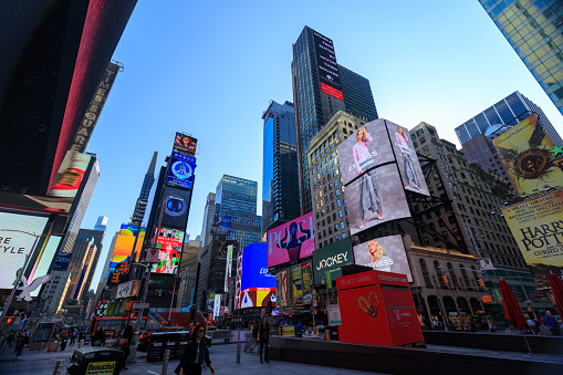 New York, USA - May 8, 2018 : The architecture of New York city in the USA at Times Square with its neon signs, stores, chaotic traffic, and tons of tourists and locals passing by.