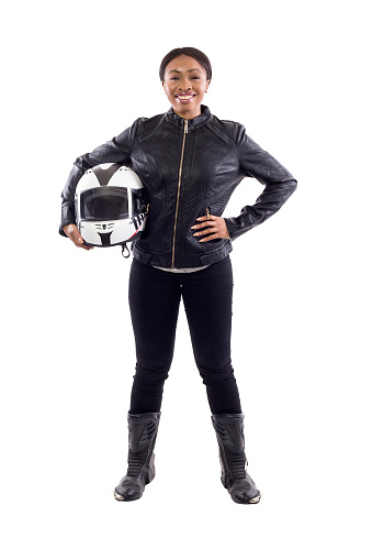 Confident strong black female holding a helmet as a race car driver, motorcycle biker or a stuntwoman.  The image depicts feminism by portraying a gritty woman of extreme motorsports.