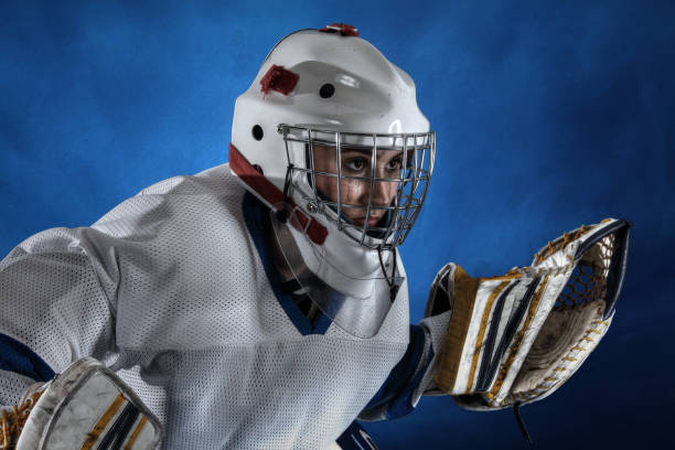 Teenage goaltender on blue background.