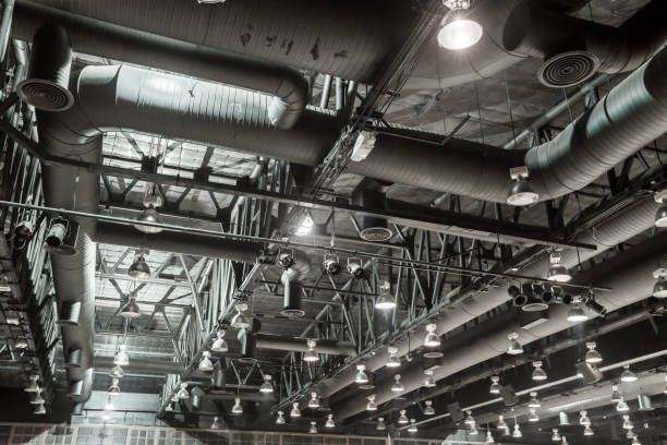 HVAC Duct Cleaning, Ventilation pipes in silver insulation material hanging from the ceiling inside new building.